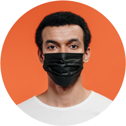 Male person of color wearing black medical face mask on orange background.