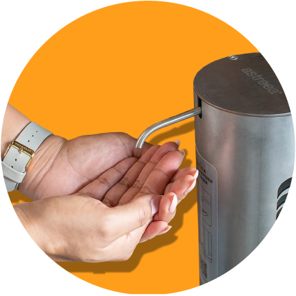 Two hands, cupped under spout of an Astreea pedal hand sanitizer unit on orange background.